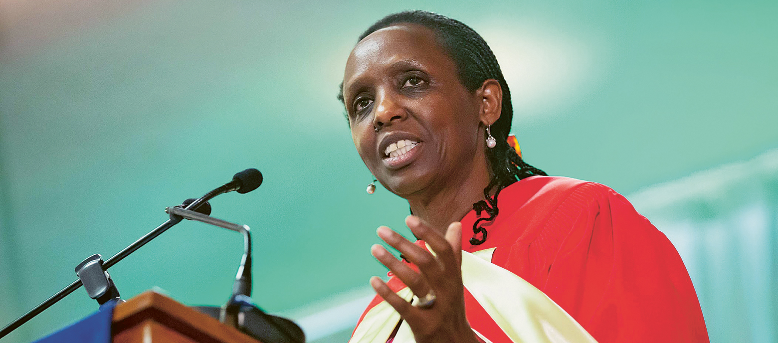 Agnes Kalibata, Spezialistin für Ernährungssicherheit und ehemalige Ministerin für Landwirtschaft in Ruanda, spricht an einem Rednerpult. Sie trägt ein rot-gelb gemustertes Gewand und Ohrringe. Ihre Haare sind zu Zöpfen geflochten. 