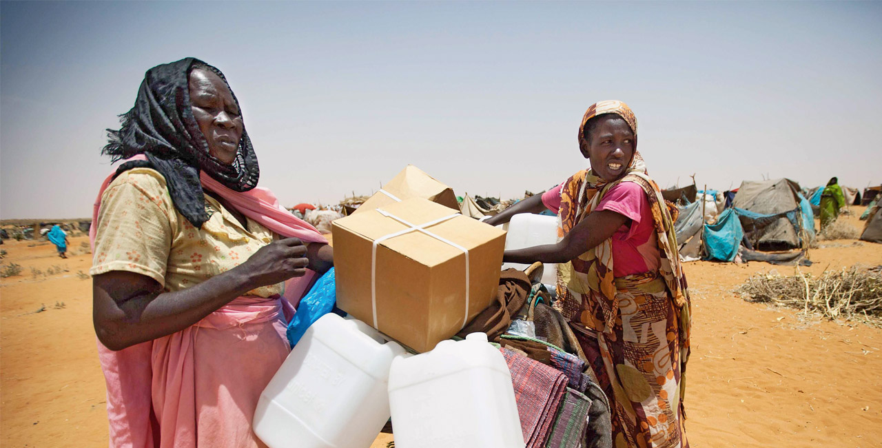 Women with aid supplies in a refugee camp in Darfur