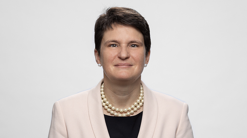 GIZ-Vorstandssprecherin Tanja Gönner im Portäit. Sie lächelt, trägt kurze dunkle Haare sowie eine Perlenkette und einen hellen Blazer.