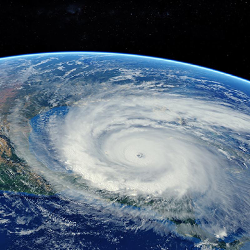 Satellitenfoto eines Hurrikans, der sich über den Ozean einem Kontinent nähert. Der Hintergrund ist schwarz und zeigt die Erde aus der Weltraumperspektive.