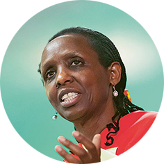 Agnes Kalibata, Spezialistin für Ernährungssicherheit und ehemalige Ministerin für Landwirtschaft in Ruanda, spricht an einem Rednerpult. Sie trägt ein rot-gelb gemustertes Gewand und Ohrringe. Ihre Haare sind zu Zöpfen geflochten. 