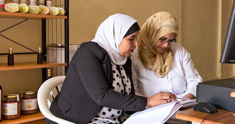 Geschäftsführerin Jamila Raissi (l.) hat die Kooperative mit aufgebaut. Hier geht sie mit einer Kollegin die Buchhaltung durch.