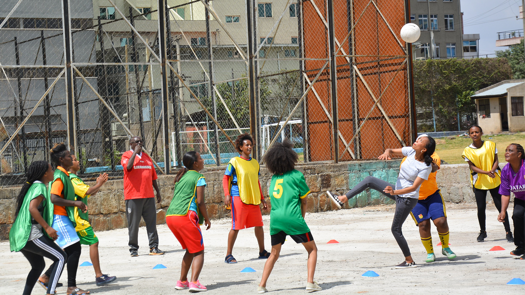 Eine Frauenmannschaft trainiert eine Ballsportart gemischt aus Fußball und Volleyball