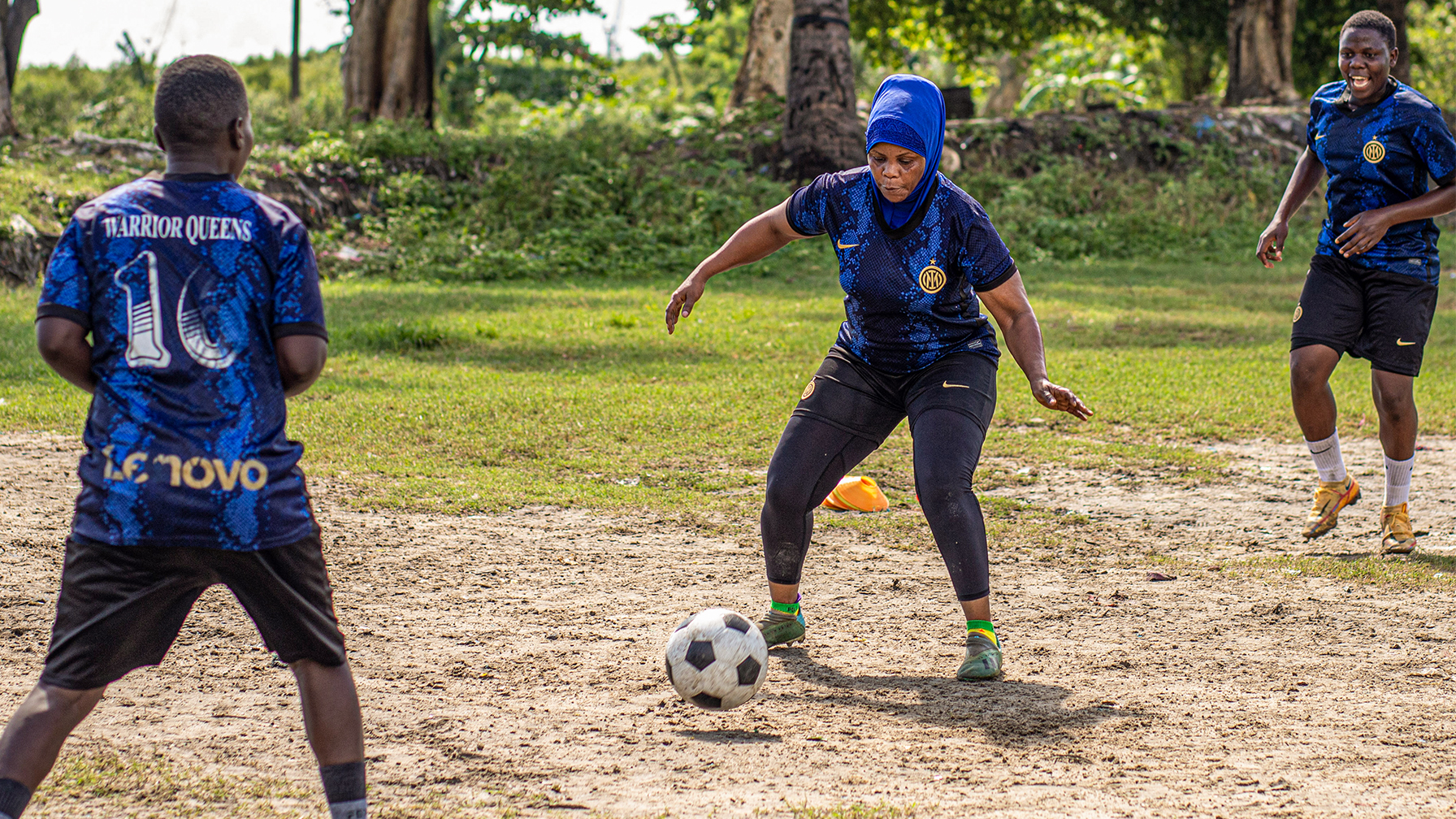  Neema Othman, coach of Warrior Queens FC trains with two men