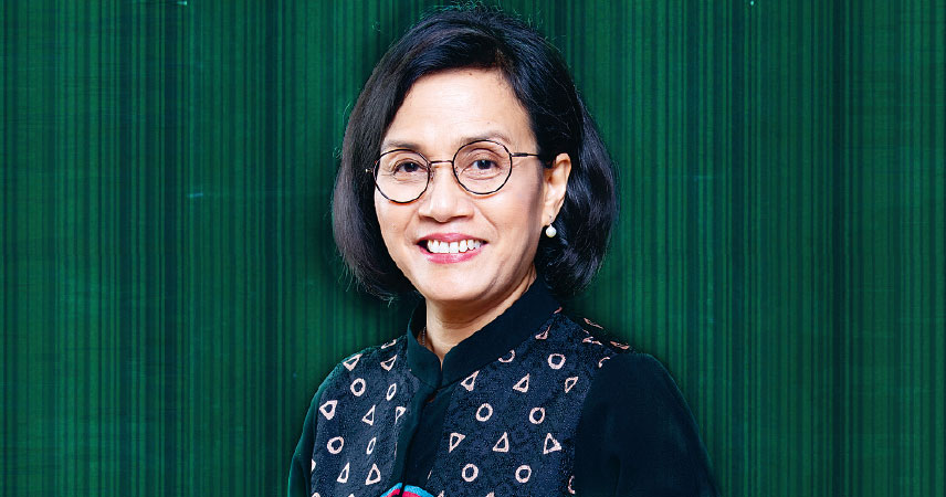 Porträt von Sri Mulyani Indrawati, eine indonesische Ökonomin. Sie trägt eine Brille mit rundem Gestell und ein dunkles, gemustertes Oberteil. Ihr Haar ist kurz, stilvoll geschnitten und sie lächelt.