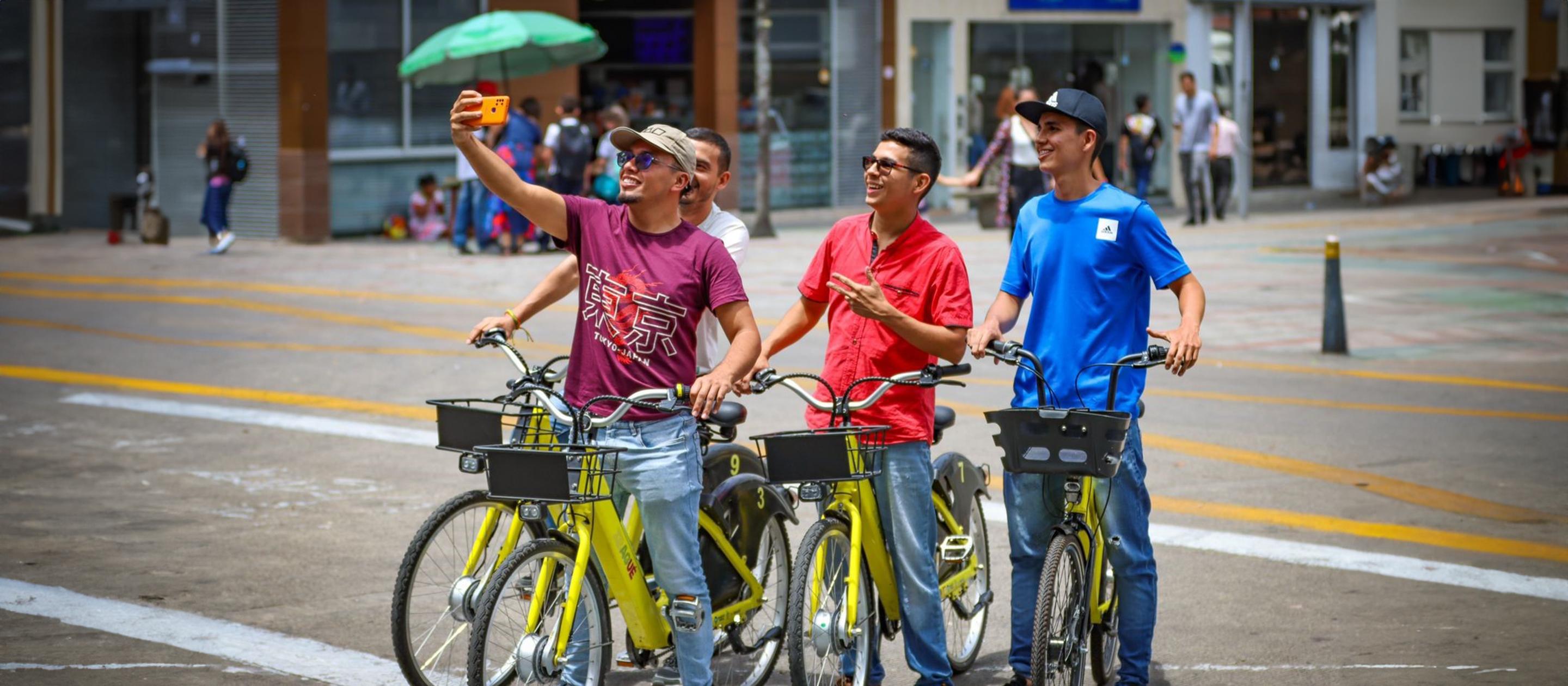 Vier Männer auf Fahrrädern posieren für ein Selfie