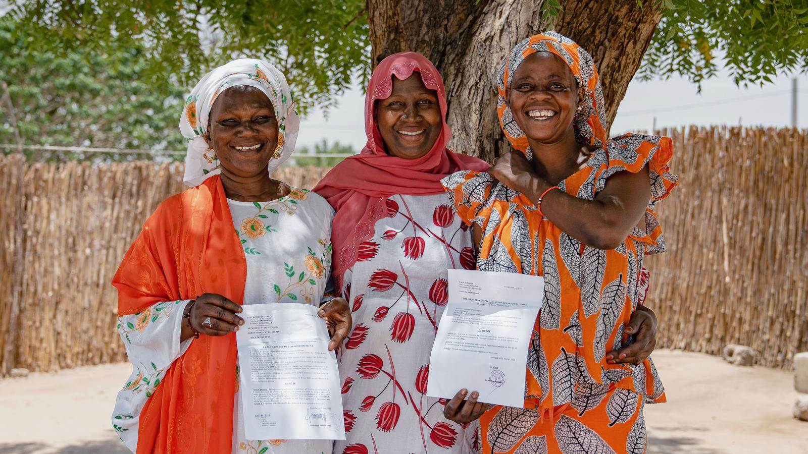 Gruppenbild mit drei Frauen, zwei halten ein Zertifikat hoch
