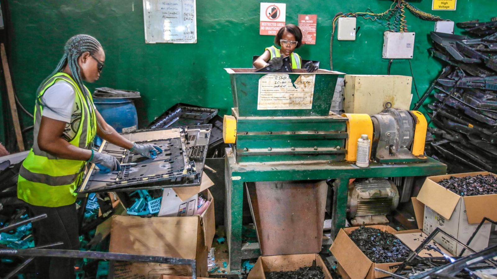Zwei Frauen sortieren Elektroschrott in einer Fabrik