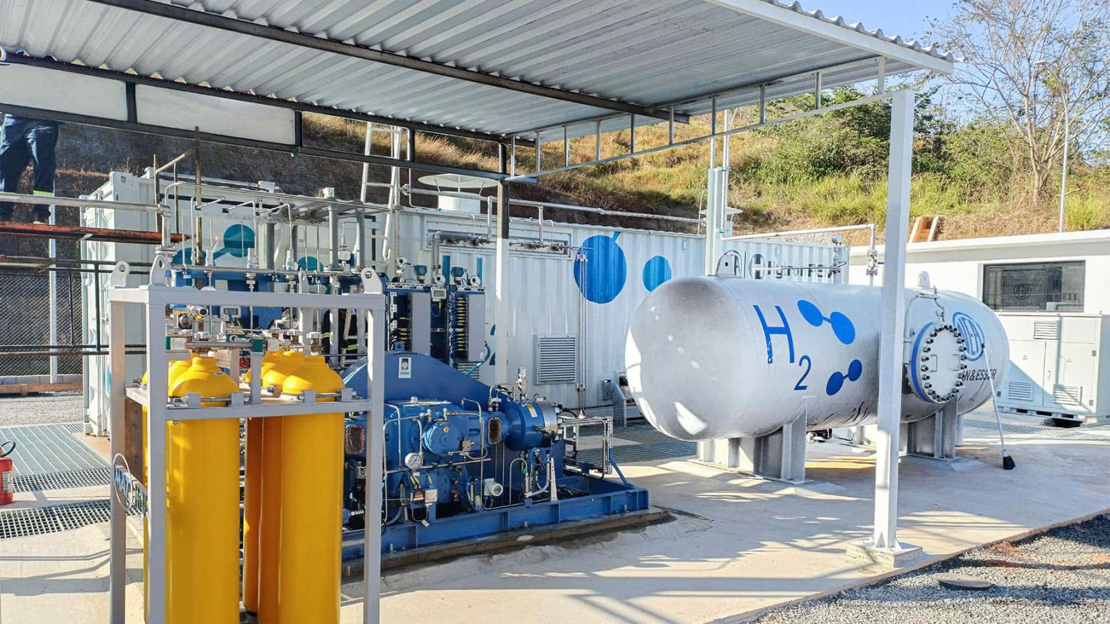 Felipe Malavazi/GIZ Brasil Eine Wasserstoff-Tankanlage mit grauem H₂-Tank und gelben Gasflaschen, überdacht und von technischen Geräten umgeben.