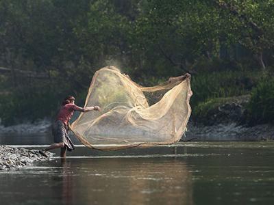 Frau wirft Netz in den Fluss
